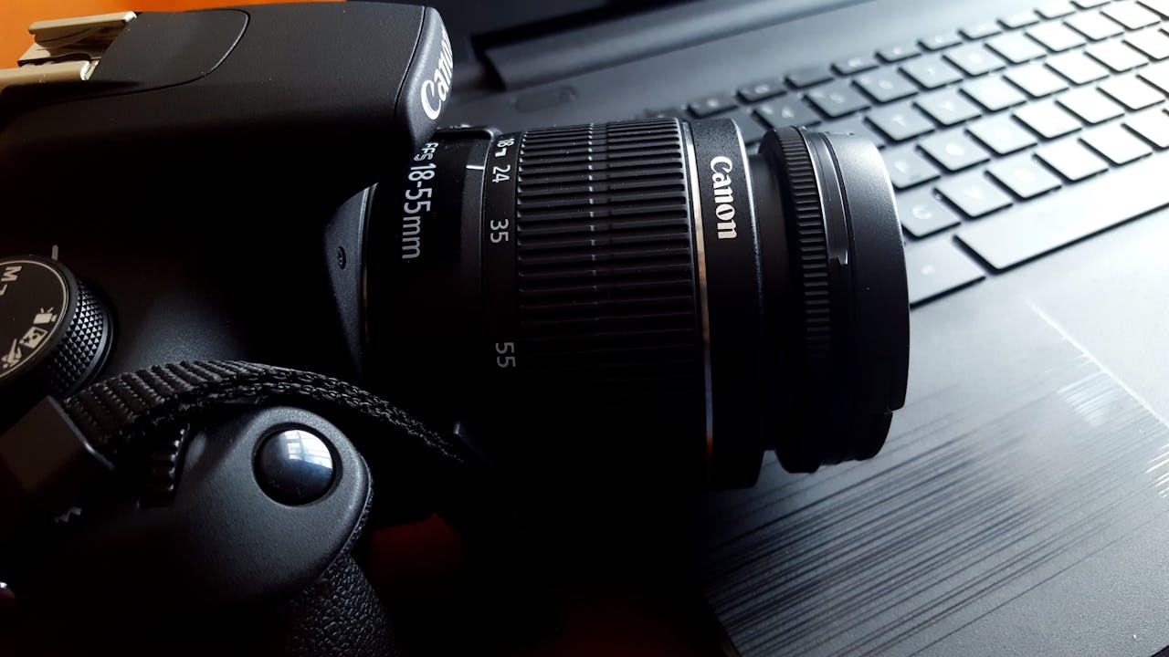 portfolio-02 Close-up of a black DSLR camera with lens on a laptop keyboard.